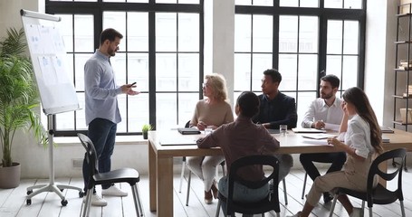 Confident coach give presentation on whiteboard at conference office meeting
