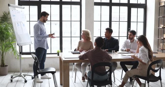 Confident coach give presentation on whiteboard at conference office meeting