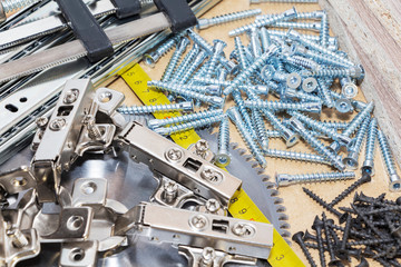 Screws, confirmations for furniture, tape measure, lie on the table. Furniture production
