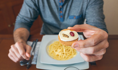 Man ready to eat crickets and cheese canape