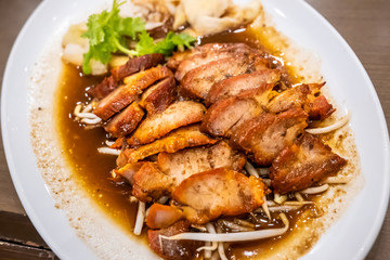 Barbecued red pork in sauce with bean sprouts.
