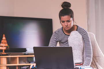 young girl working on laptop at home in living room