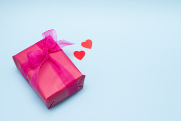 red gift box with heart on blue background, top view