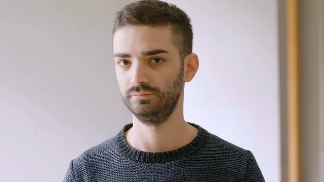young serious man looking at camera and shaking his head 