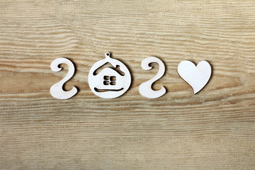house and heart form the number two thousand twenty on a wooden surface top view. anniversary year...