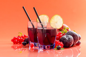 Fruit juice rich of anthocyanins, oligominerals for health in glass on colored background.