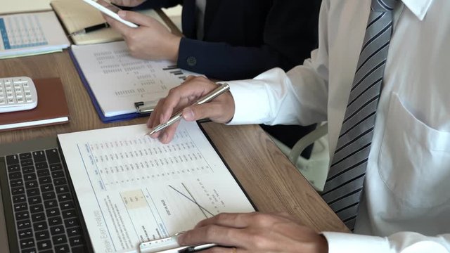 4k video of Business People Talking Discussing with coworker planning analyzing financial document data charts and graphs in Meeting and successful teamwork Concept.