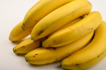 Bunch of ripe yellow bananas on a white background. Close up.