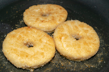 Three minced chicken cutlets are fried in a pan in vegetable oil. Close up.