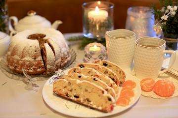 Christmas cupcake with dried fruits from prunes, raisins, dried cherries and nuts on the background of a tea set, Christmas tree branches and a lit candle