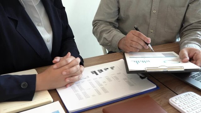4k video of Business People Talking Discussing with coworker planning analyzing financial document data charts and graphs in Meeting and successful teamwork Concept.