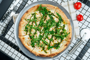 Tasty pizza with chicken, arugula and parmesan on a white background. Italian traditional cuisine. Delicious food flat lay. Top view