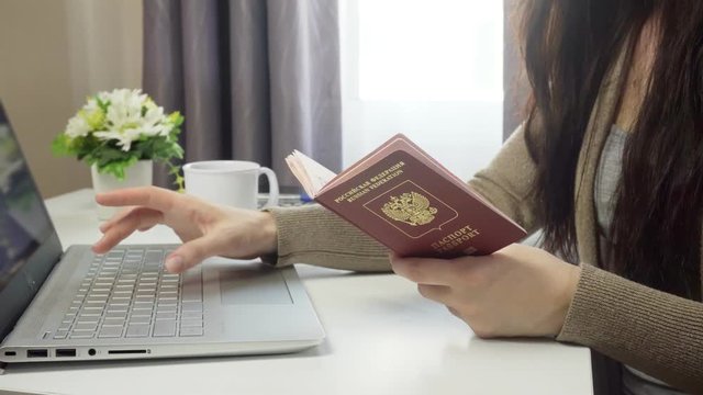 Young woman booking travel ticket in online store with credit card and computer.