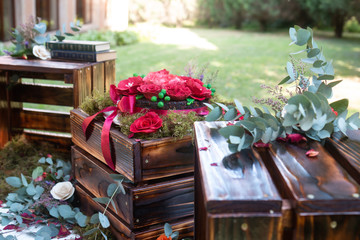 A table decorated with red flowers and greenery
