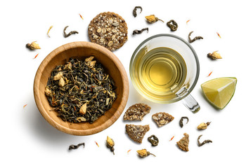 Groene thee met natuurlijke smaken en een kopje. Bovenaanzicht op witte achtergrond