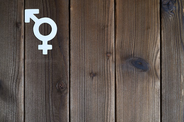 symbol for gender equality cut out of paper on a wooden background. space for text