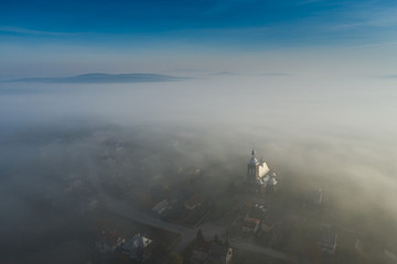 Surreal view of church almost completely hidden by fog