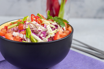 Diet salad made from fresh vegetables. Peking cabbage lilac and green, tomatoes, green onions and chili peppers. Dressed with olive oil.