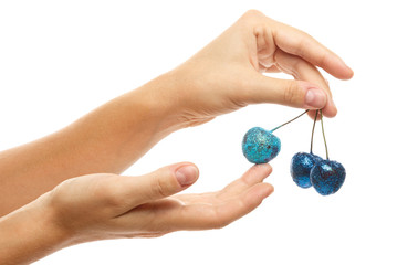 Female hands and cherry berries covered with a colorful glitters