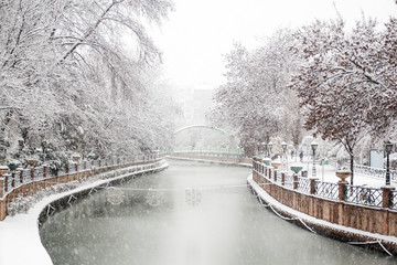 Beautiful Snow Landscape of Porsuk River with bridge and trees at the background in Winter season, in Eskisehir, Turkey. Beautiful view of snow in city center.