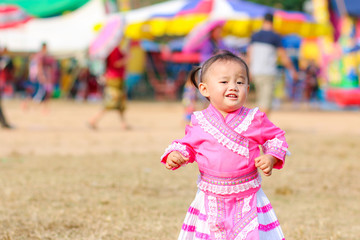 Naklejka premium Little child in Hmong costumes running on the ground on Hmong new year festival 2020