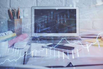 Stock market graph on background with desk and personal computer. Double exposure. Concept of financial analysis.