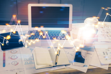 Stock market graph on background with desk and personal computer. Multi exposure. Concept of financial analysis.