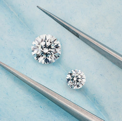 Pair of Round Brilliant Cut Diamonds on Blue Background