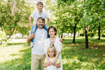 Fototapeta premium Family portrait of all the members standing in the park.