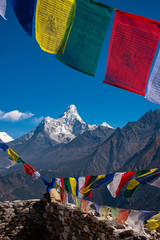 Colourful buddhist tibetan prayer flags (Lungta) with Wonderful view of mountain Ama Dablam in the Himalaya range, eastern Nepal