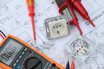 Sockets with a screwdriver and a measuring device on a circuit diagram