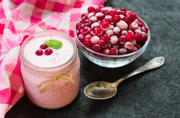 Healthy yogurt made from frozen cranberries on a black background. The concept of healthy desserts. View from above.