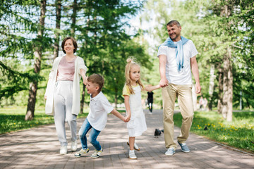 Naklejka na ściany i meble Big happy family with two kids walk in the park.