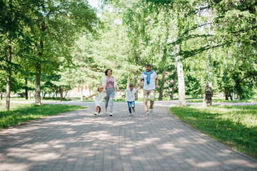 Big family with two kids walk in the park.