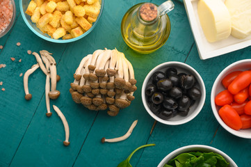 Fresh ingredients on wooden texture. Mushrooms, olives.