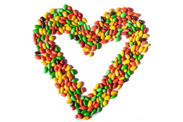 Happy Valentine's Day. A beautiful postcard with a bunch of colorful candies laid out in the shape of a heart on a white isolated background. The concept of the February holiday. 