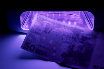 Authentication with infrared light at the detector. Paper bill in ultraviolet color. Fifty Euros 50 Euro.
