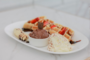 ice cream with  Belgium waffles and and strawberries.
