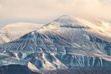 felsiges schneebedecktes Bergmassiv in goldenem Sonnenlicht - grandiose Landschaft der Arktis