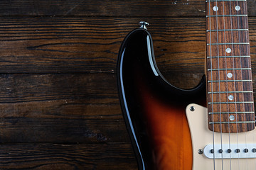 Close-up on electric guitar on vintage old wooden background