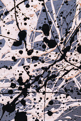 Picture painted using the technique of dripping. Mixing different colors white and black. Lines and spots. Vertical orientation.
