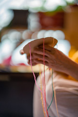 Making a braided friendship bracelet using a cardboard and yarn.