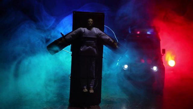 Lethal injection concept. Prisoner handcuffed to death by lethal injection. Creative artwork decoration with scale model on dark with lights.