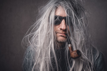 Portrait skuril crazy Mann graue lange Haare und Sonnenbrille mit Pfeiffe Var.2