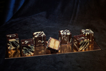 hand-made chocolates, each candy is different and unique. Dark chocolate on velvet and gold