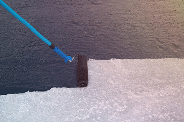 Worker applies bitumen mastic on the foundation