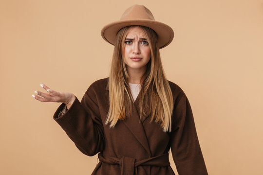 Image of young girl wearing hat frowing and holding copyspace on her palm