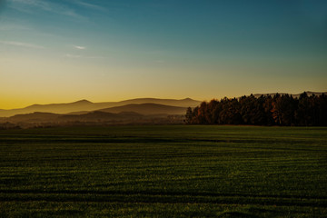 Fototapeta na wymiar rising sun panorama of meadows and hills