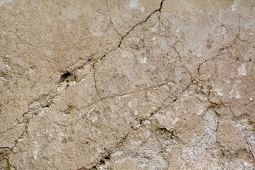 Cracked beige clay wall. Background. Texture