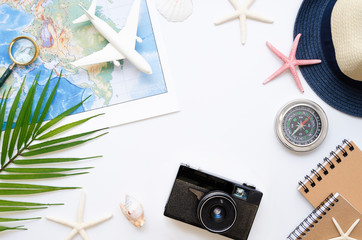 White travel table concept. Flat lay straw hat, palm leaf, map and starfishes. Summer tourism...